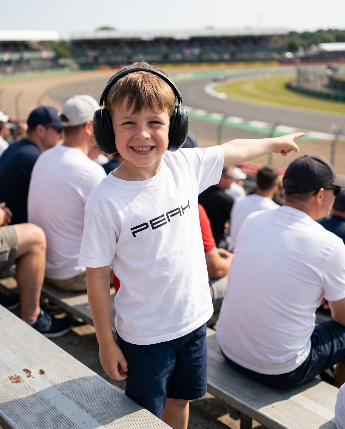 Boy wearing the PEAK Kids Tee in White in a grand prix grandstand