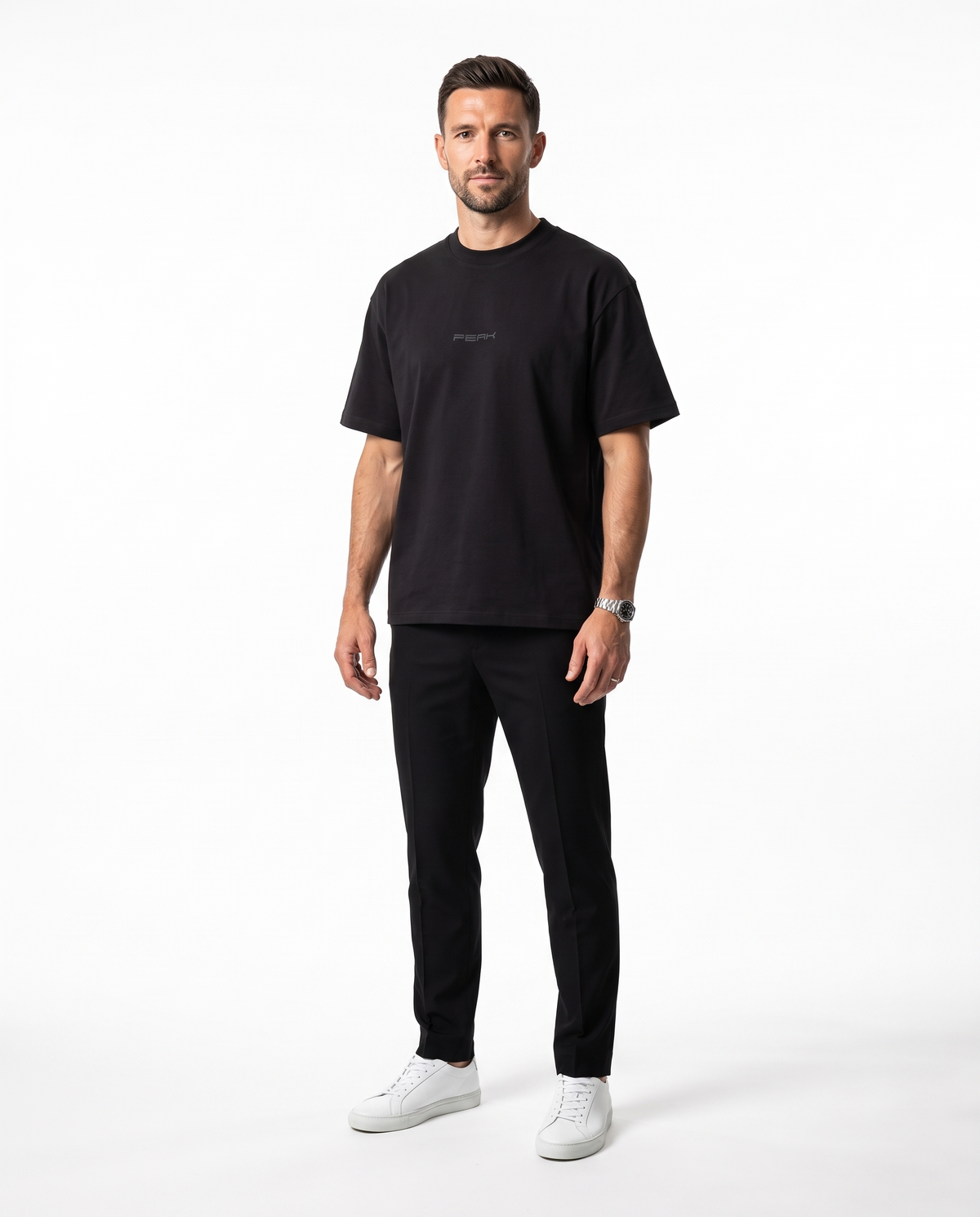 Man wearing the PEAK Tonal Tee in Black with a charcoal chest wordmark