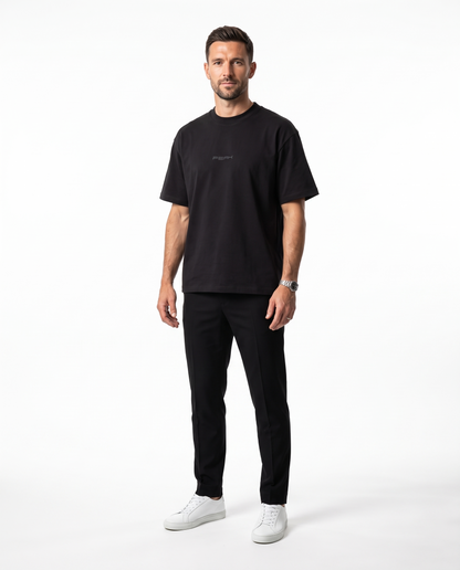 Man wearing the PEAK Tonal Tee in Black with a charcoal chest wordmark
