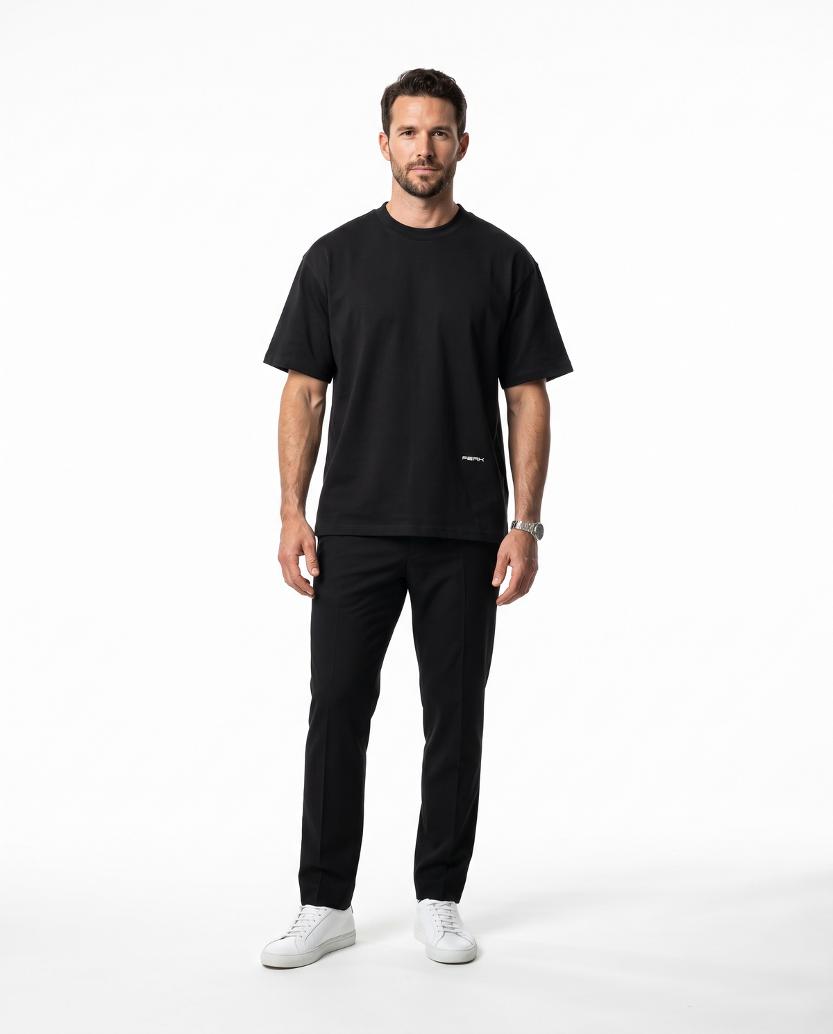 Man wearing the PEAK Hem Tee in Black with a small wordmark low on the front