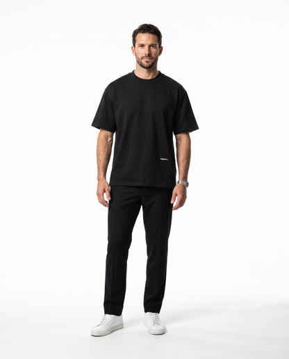 Man wearing the PEAK Hem Tee in Black with a small wordmark low on the front