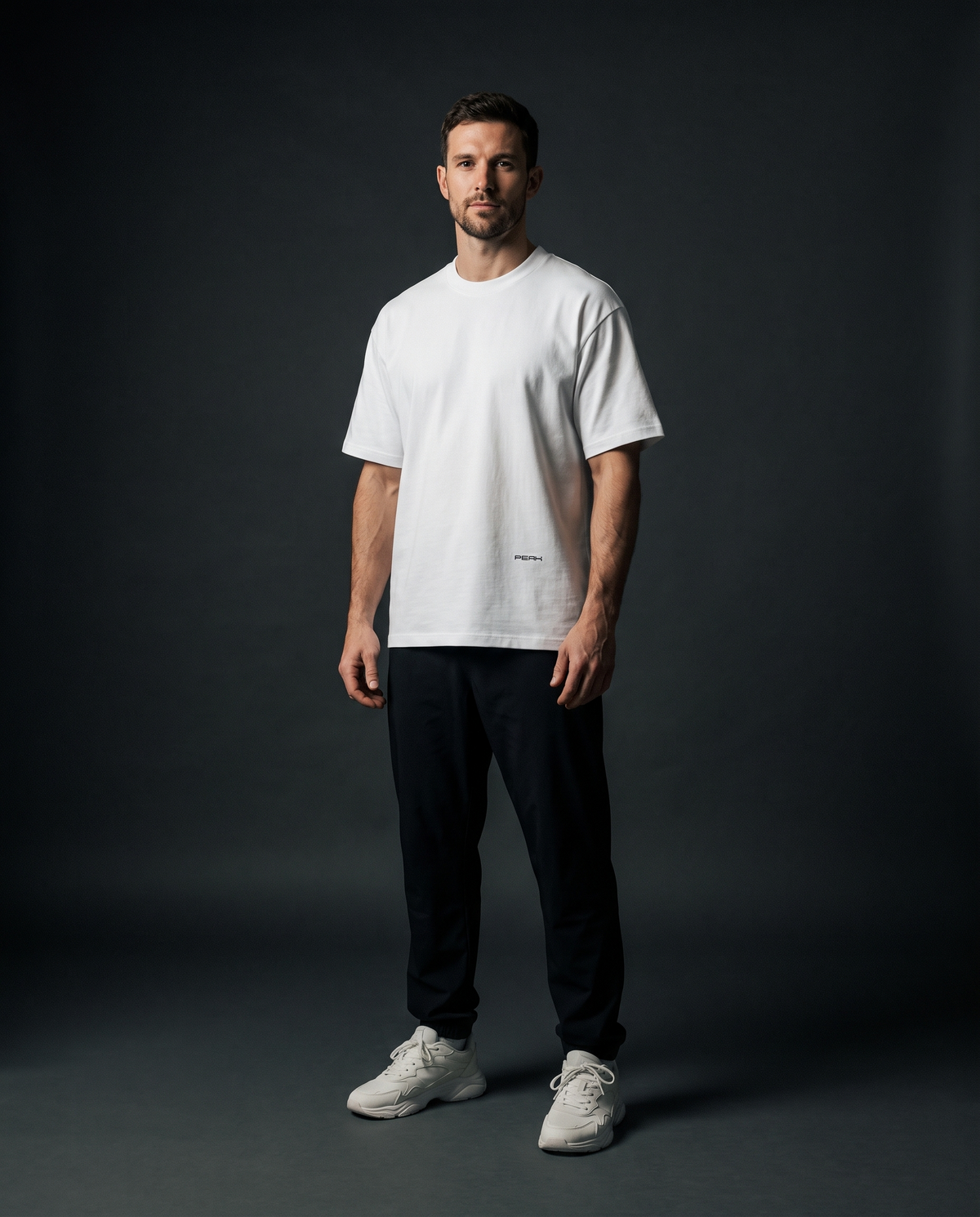 PEAK Hem Tee in White worn in a dark studio