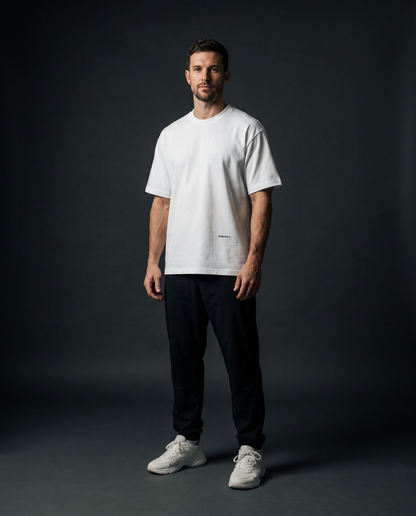 PEAK Hem Tee in White worn in a dark studio