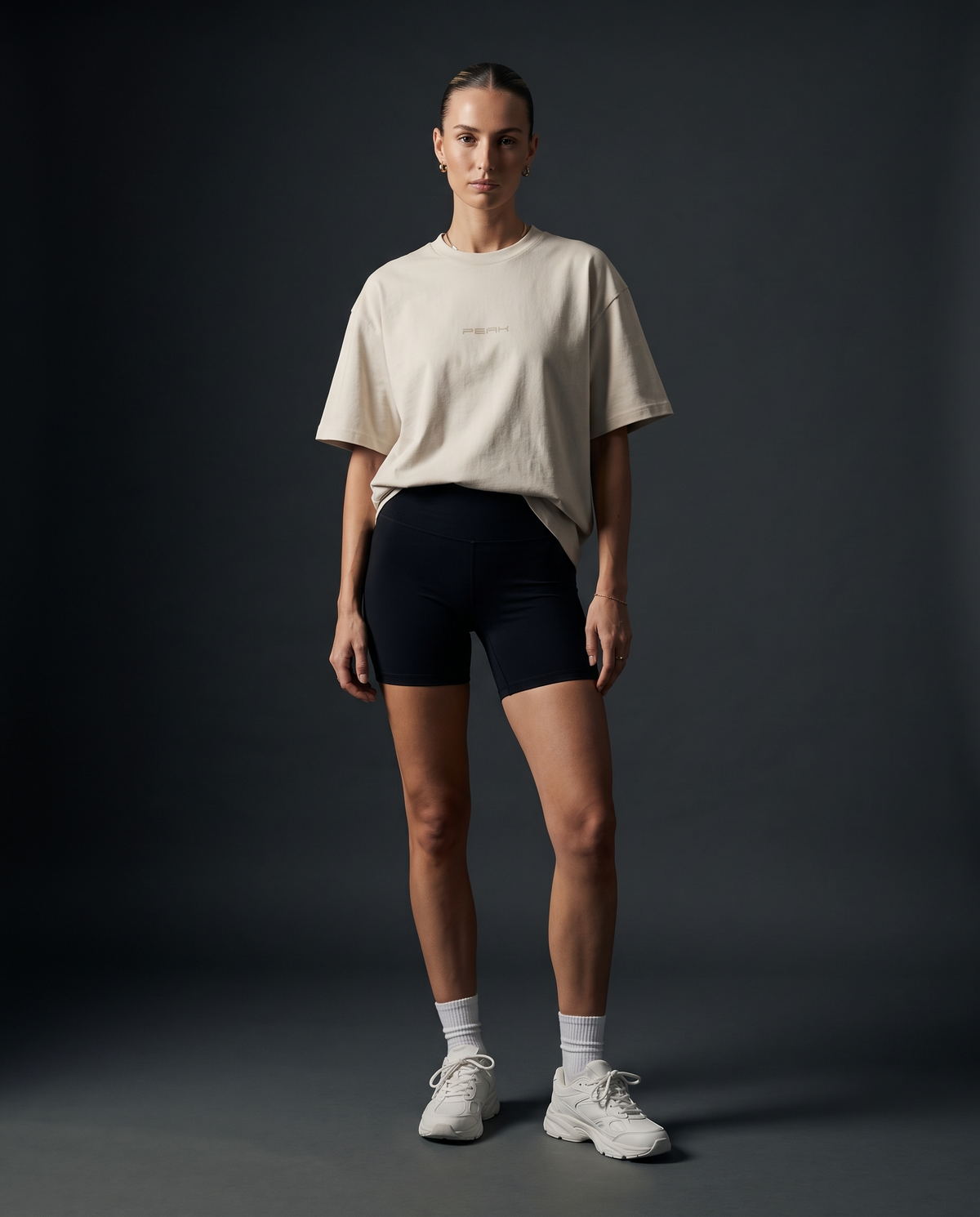 Woman wearing the PEAK Tonal Tee in Ecru with a sand chest wordmark