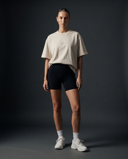 Woman wearing the PEAK Tonal Tee in Ecru with a sand chest wordmark