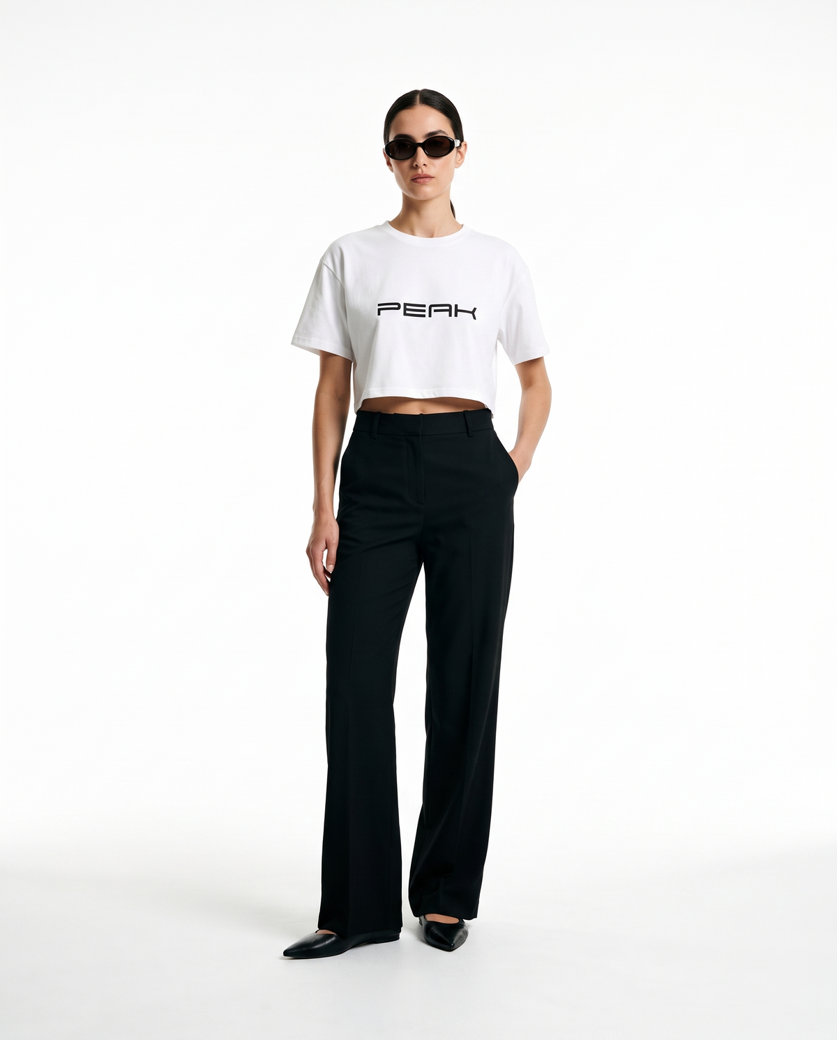 Woman wearing the PEAK Women's Crop Tee in White