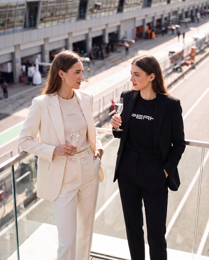PEAK Tonal Tee in Ecru with a cream suit on a race weekend terrace
