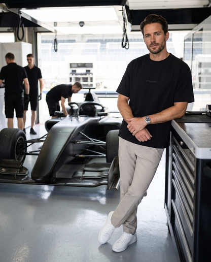 Man wearing the PEAK Tonal Tee in Black in a race team pit garage